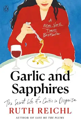 Book cover for Garlic and Sapphires by Ruth Reichl: a woman in a red top pours sauce onto pasta at a table, with a glass of wine beside it; bold title text at the bottom.