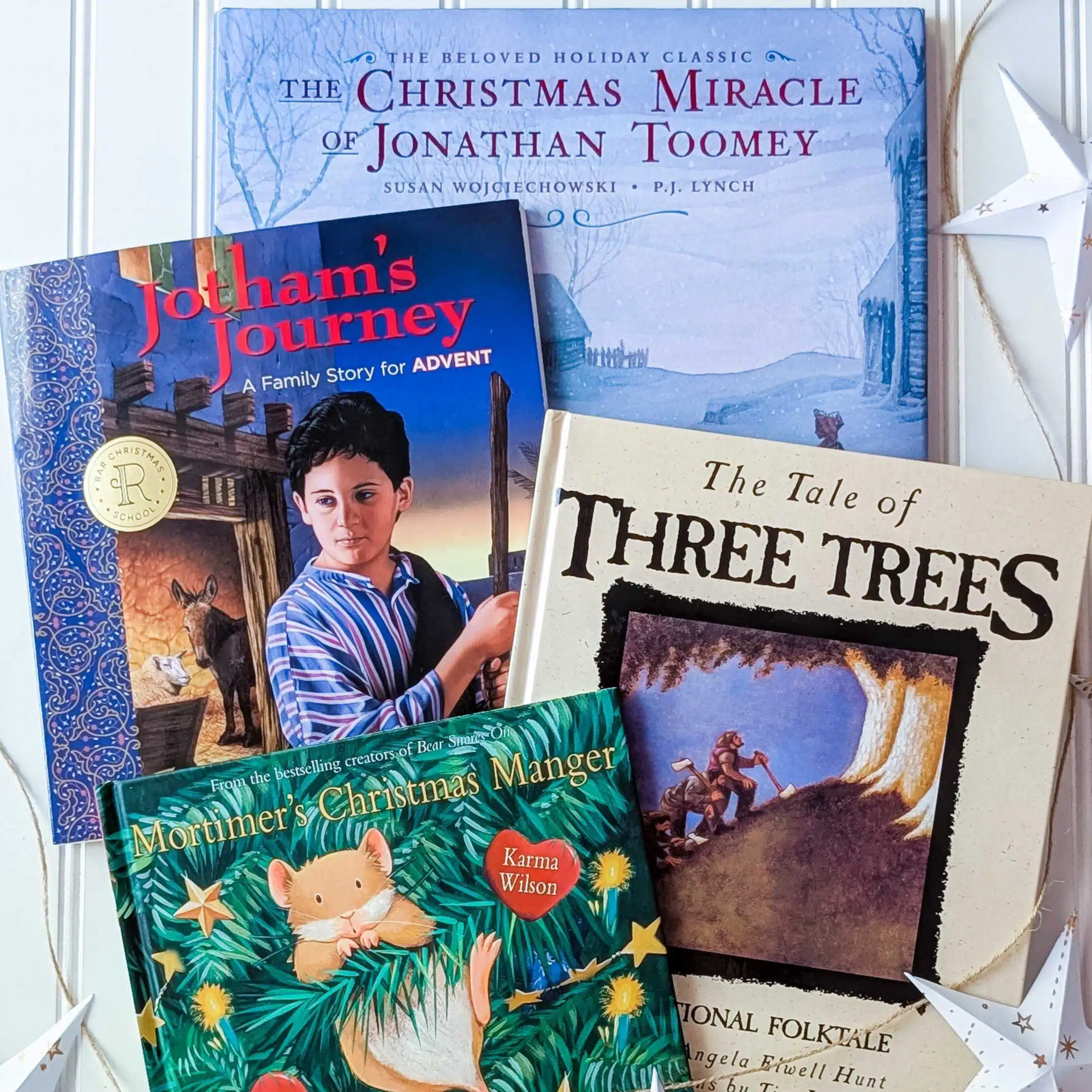 Christmas School 2026 books - Read-Aloud Revival ® with Sarah Mackenzie Several Christmas-themed children's books stacked together on a white shelf.